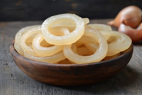Translucent pork rind rings in a bowl. Perfect for illustrating food blogs, recipes, or articles about snacks.