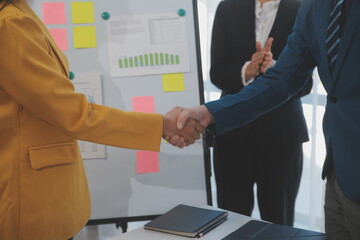 Hand shake business,Young business people shaking hands in the office. Finishing successful meeting. Three persons