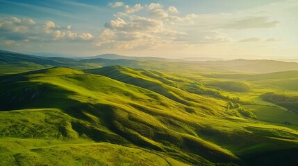 Obraz premium Scenic Green Hills Under Bright Sky with Golden Sunlight