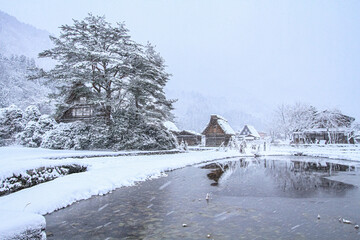 Gassho-Zukuri Farmhouse Reflected in Pond in Snowy Shirakawa-go Japan