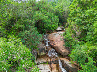 Aerial drone view of an amazing waterfall with unique rocks formations at Batu Ferringhi, Penang Island, Malaysia.