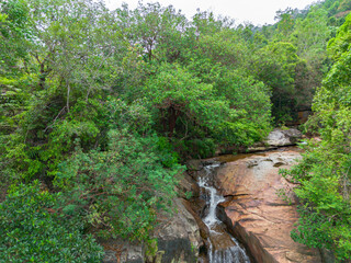 Aerial drone view of an amazing waterfall with unique rocks formations at Batu Ferringhi, Penang Island, Malaysia.