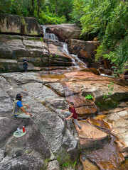 Aerial drone view of an amazing waterfall with unique rocks formations at Batu Ferringhi, Penang Island, Malaysia.