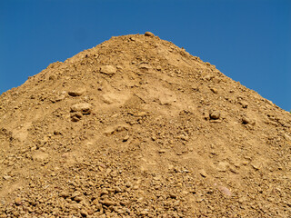 Earth mound construction activity outdoor site clear sky ground level heavy machinery use