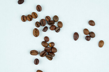 Roasted coffee beans scattered on a white surface
