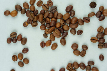 Scattered coffee beans on light background