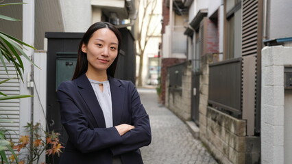 路地で待ち合わせをする腕組みをした女性