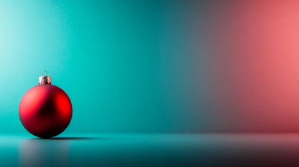 Fototapeta premium A smooth red Christmas ornament rests against a pastel blue gradient backdrop, creating a contemporary look perfect for festive designs and holiday greetings