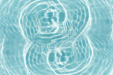 Blue water with ripples on the surface. Defocus blurred transparent blue colored clear calm water surface texture with splashes and bubbles. Water waves with shining pattern texture background.