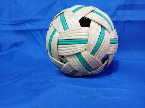 sepaktakraw or takraw or  buka ball, kick volleyball or foot volleyballball on blue background, closeup of photo taken in malaysia.