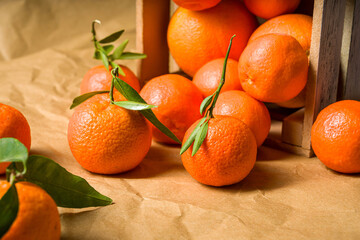 Front view of freshly picked organic tangerines in a wooden crate. Tangerine box