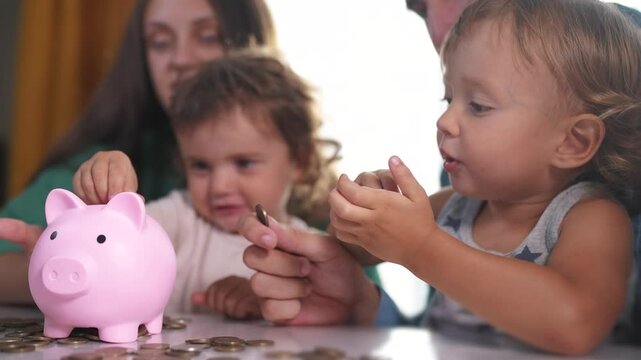 Family and group of babies put coins into piggy bank. the concept of the economy of a young family. family with children and piggy bank with money. a family with a baby lifestyle and coins in a bank.