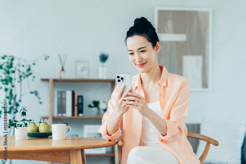 Wall mural 家でスマホを使う若い女性