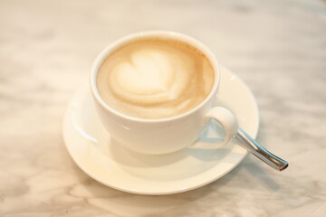 Cup of Cappuccino with Heart Shaped Latte Art on Table