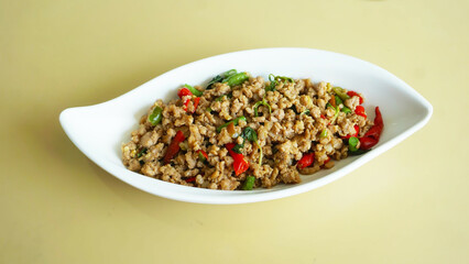 Stir-fried Minced Pork with Chili Peppers and Basil: A tempting dish of stir-fried minced pork with chili peppers and basil, served on a white plate.