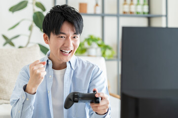 テレビゲームをする若い男性 © pain au chocolat