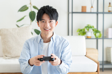 テレビゲームをする若い男性