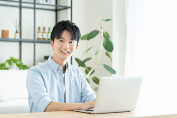 リビングでパソコンを使う若い男性