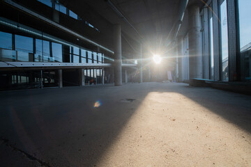 A captivating view of a modern business building under construction, showcasing its raw industrial interior with exposed steel beams and concrete walls bathed in the warm, golden hues of a sunset
