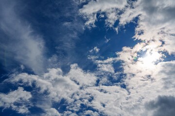 Obraz premium This captivating image features a vibrant blue sky filled with soft, fluffy white clouds, creating a tranquil and uplifting atmosphere. Ideal for backgrounds, presentations, or creative projects.