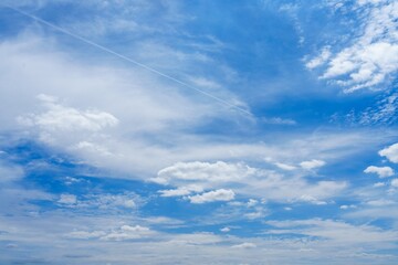 A stunning view showing a vast blue sky adorned with beautiful white fluffy clouds, ideal for nature enthusiasts and perfect as a serene background for various creative projects.