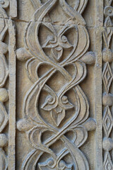 A historical building framed with artistically carved stonework. Architectural detail from the Divriği Great Mosque and Hospital, listed on the UNESCO World Heritage List. Floral and geometric motifs.