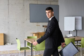 Fototapeta premium A determined businessman in a black suit confidently walks through the office, embodying professionalism and focus as he heads towards new challenges
