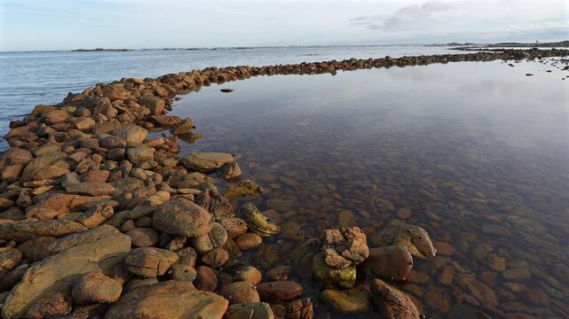 Ancient Rasperpunt fish traps along the L'Agulhas shoreline in the  Agulhas National Park. These tidal fish traps were probably built by pre-colonial Late Stone Age people. Western Cape. South Africa.