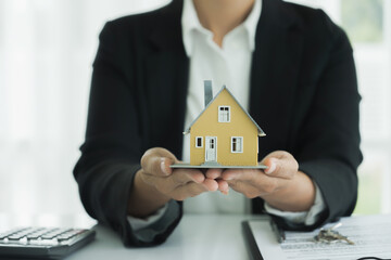 Real estate agent handing house model