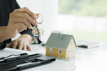 Real estate agent handing property keys to customer.