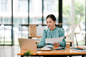 Young Asian woman doing financial accounting and taxes for a company Organizing account analysis reports Investment information Financial and tax system concepts