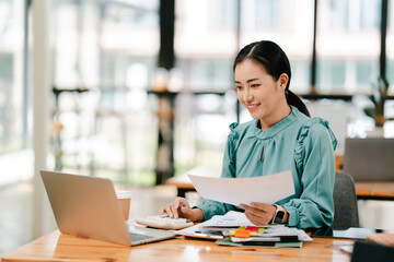 Young Asian woman doing financial accounting and taxes for a company Organizing account analysis...