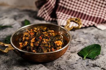 stewed spinach with rice and tomato sauce in traditional turkish brass pan