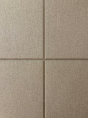 Fototapeta premium Brown beige and ivory color fabric, series of upholstered panel wall with beveled rectangular pattern. This functions as padded wall to sound insulation, or accoustic wall.