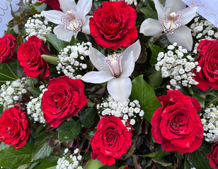 Red roses and white flowers of a wreath in the public cemetery