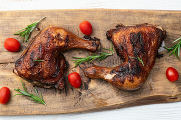 Grilled chicken legs with tomatoes and salad . Top view
