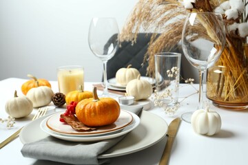 Rustic holiday table setup with plates, cutlery and autumn decorations