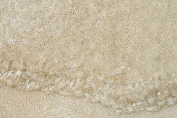 Gentle waves lap at a soft sandy beach under the warm glow of dusk in a tropical paradise.