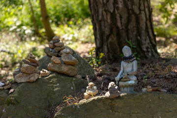 A small stone pagoda and a Buddha statue under a tree