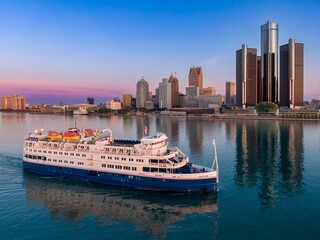 Detroit skyline at dawn, cruise ship navigating the river. Beautiful morning light. DOWNTOWN,...