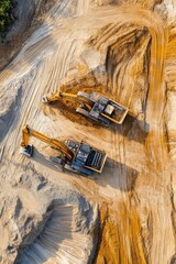 Aerial view of construction machinery working on sandy terrain.