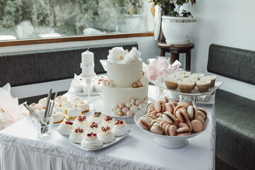 Delicious sweet buffet with with cake, cupcakes, macaroons and biscuits. Luxury Candy Bar for celebration, wedding, birthday