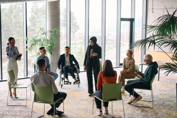 Obraz premium Corporate business team meeting with a manager or coach. Group of happy diverse, multiracial people sitting in a circle 
