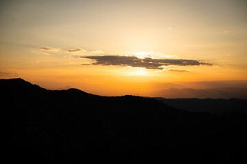 Atardecer entre las montañas con tonos naranjas