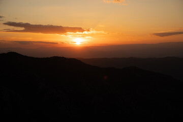 Atardecer entre las montañas con tonos naranjas