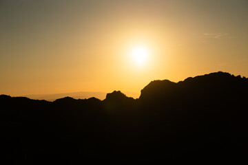 Atardecer entre las montañas con tonos naranjas