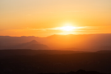 Atardecer entre las montañas con tonos naranjas
