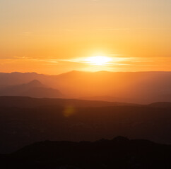 Atardecer entre las montañas con tonos naranjas