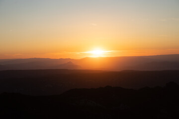 Atardecer entre las montañas con tonos naranjas