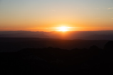 Atardecer entre las montañas con tonos naranjas